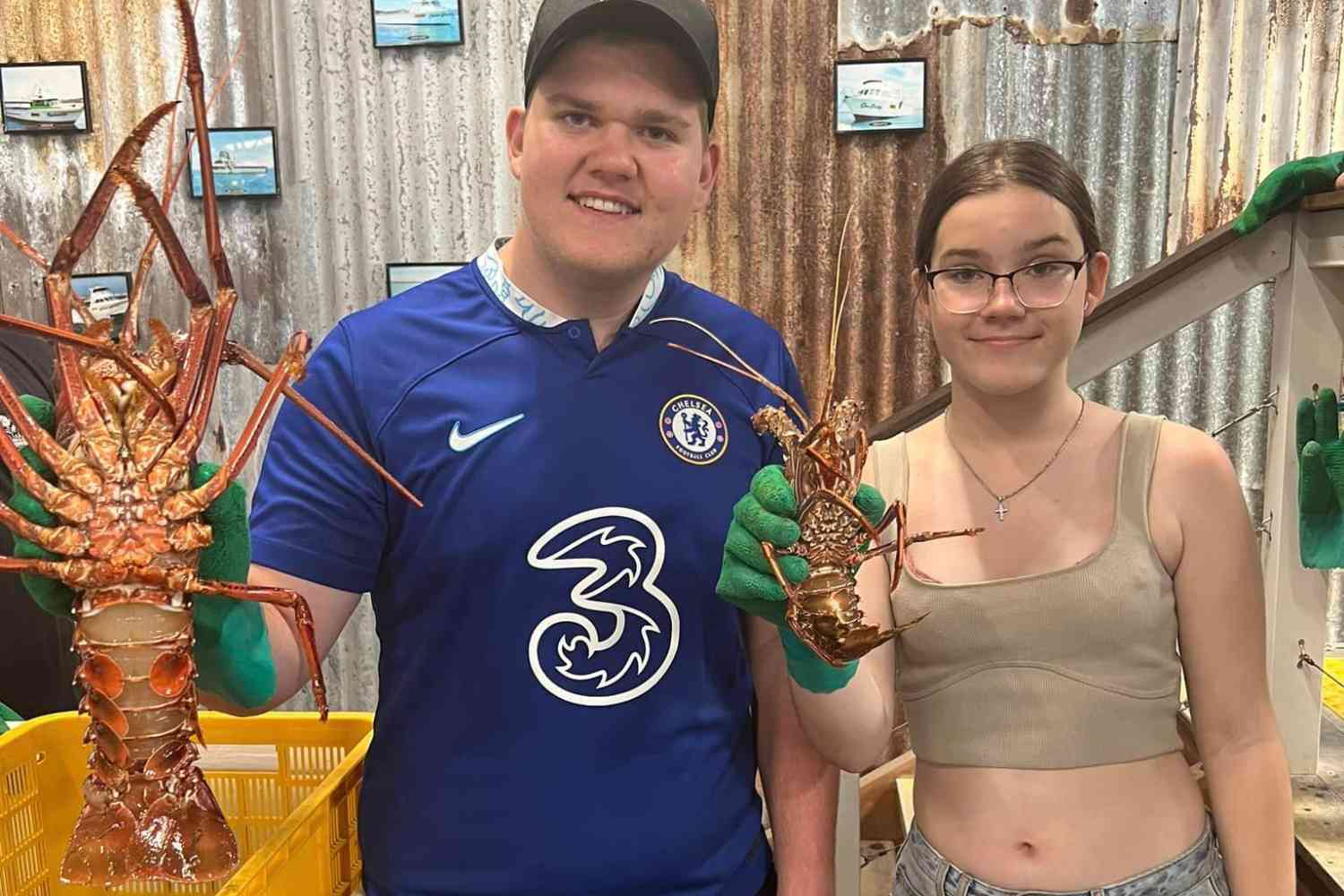 Two children hold up crayfish at the Lobster Shack in Cervantes